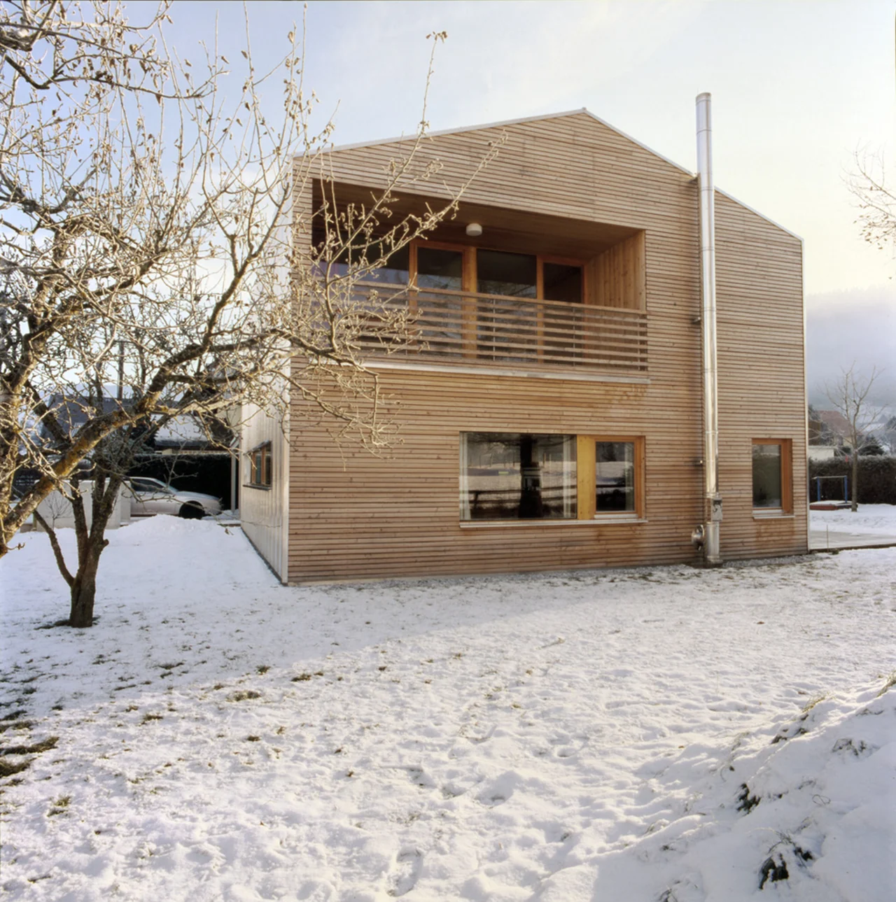 Mehrgeschossiges Einfamilienhaus mit Holzfassade im Winter
