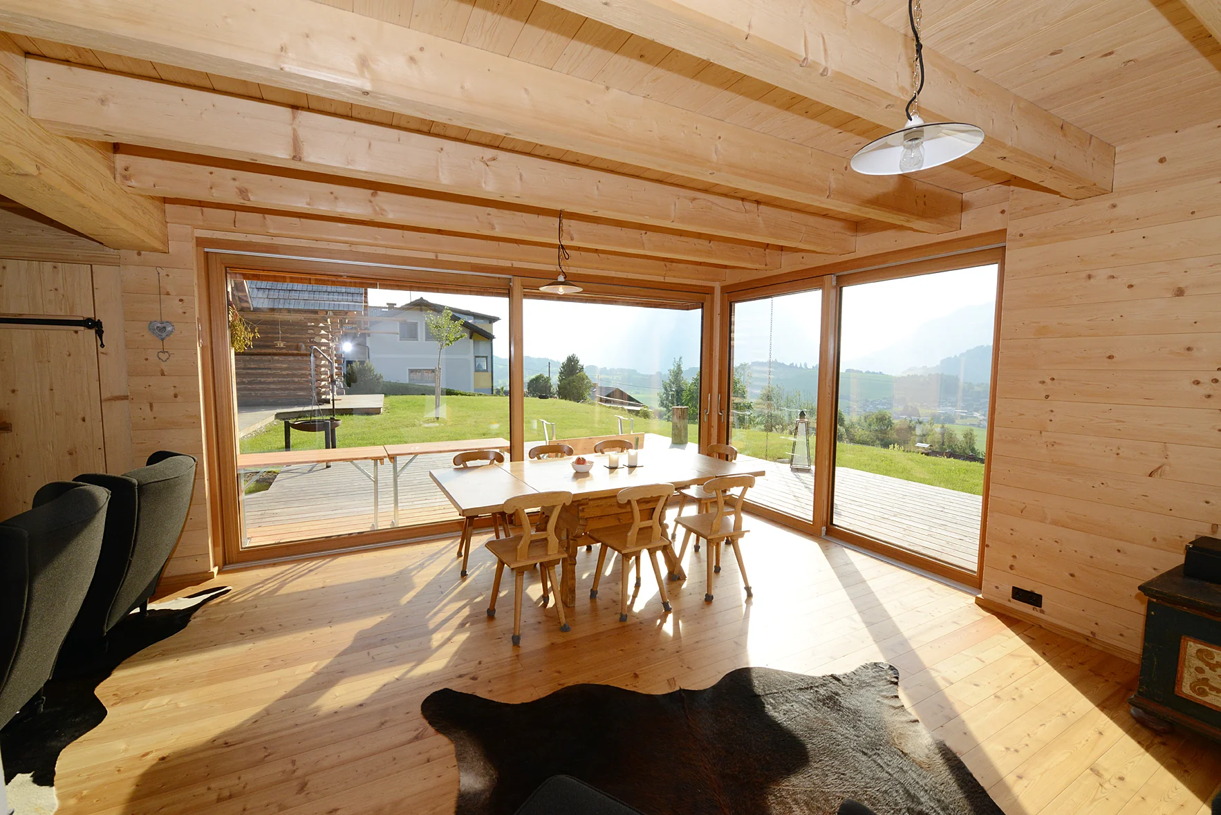 Wohnraum mit Holzdecke und Blick in den Garten
