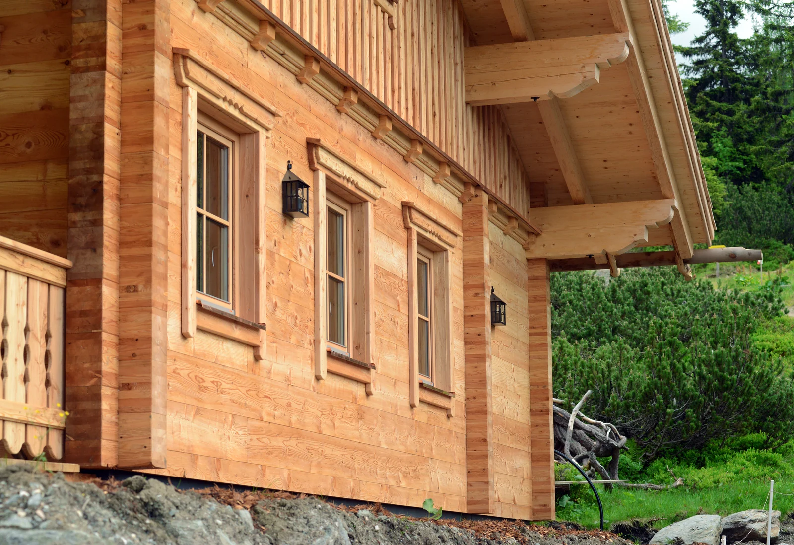 Blockholzfassade mit Fenstern und sorgfältig ausgeführter Hausecke